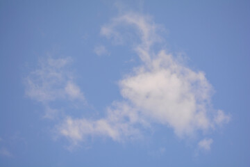 Fluffy white clouds float effortlessly in a vibrant blue sky, creating a serene backdrop. The tranquil atmosphere hints at a peaceful day, ideal for outdoor adventures or relaxation