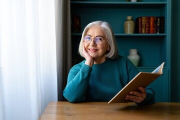 Portrait of a senior woman reading a book at home enjoying her retirement years life