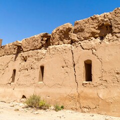 Ancient Eroded Wall With Openings Under Blue Sky in Bright Sunlight