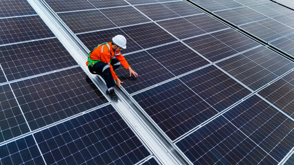 Engineers or technicians in safety gear meticulously inspecting and maintaining large-scale solar panel installations on a rooftop, emphasizing sustainable energy solutions.