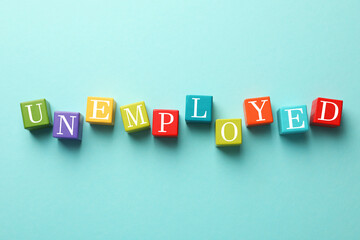 Unemployment. Colorful cubes on light blue background, flat lay