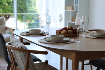 Beautiful table setting, chairs and decor in dining room. Interior design