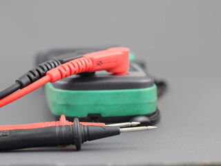 Digital clamp meter with probe test isolated on grey background.