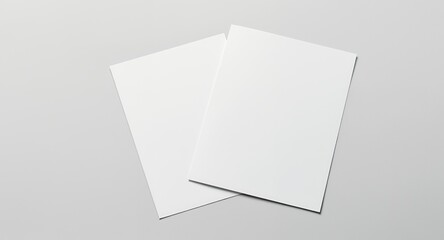 Two Blank White Sheets of Paper on a Light Gray Surface
