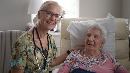 Portrait of smiling happy nurse engaging with an elderly woman in a senior living facility, checking her vitals while enjoying a friendly conversation together.
