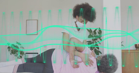 Stretching physiotherapist wearing mask assisting patient on home therapy table with green waveform