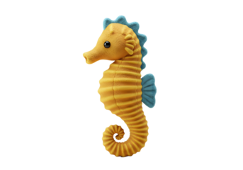 A yellow seahorse plush with a blue mane and fin stands on a white surface casting a soft shadow