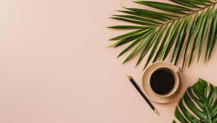 Flatlay of a pale pink background featuring a cup of coffee, pen, and tropical leaves arranged asymmetrically, leaving ample negative space