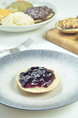 Serabi pancakes topped with blueberry jam, a traditional Indonesian snack