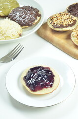 Serabi pancakes topped with blueberry jam, a traditional Indonesian snack