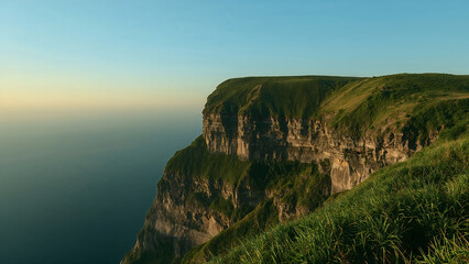 Dramatic Cliff Overlooking the Ocean during Golden Hour Calm Serene Scene