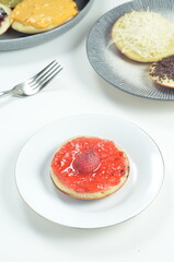 Serabi pancakes topped with strawberry jam, a traditional Indonesian snack
