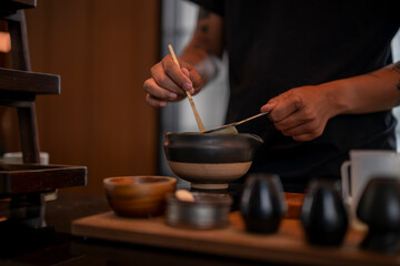 Chef preparing matcha green tea with traditional tools