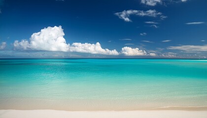 Obraz premium wide beach turquoise water fluffy clouds