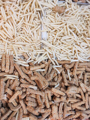 Top angle shot of frozen fried food. Frozen food consisting of French fries, chicken strip nuggets, and fish cakes. Half-cooked instant food sold in supermarkets. Food ingredients backgrounds