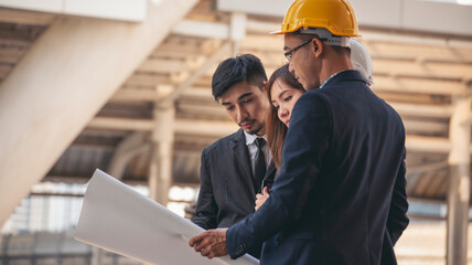 Group of construction engineer look at blueprint architecture building contractor design in modern city. Partner team engineer holding project planing project teamwork. Engineering construction site