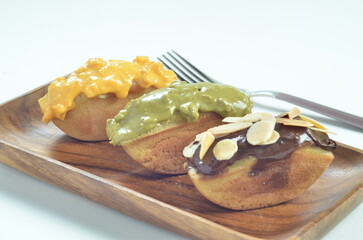 Pukis cake with various toppings of chocolate, cheese, peanuts, and matcha, a traditional Indonesian snack