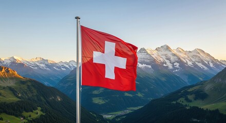 Swiss flag flying over a scenic alpine valley with snow-capped mountains at sunrise.