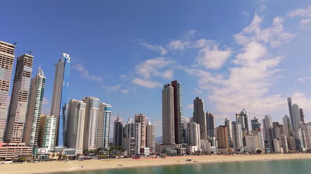 Beachfront skyline of Balne&aacute;rio Camboriu, Santa Catarina, Brazil, with iconic towers as Yachthouse Residence Club, One Tower, Infinity Coast, Epic Tower rising above Avenida Atl&acirc;ntica, drone orbiting