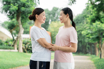 Mother and daughter holding hands sharing a moment in the park connecting through love and support