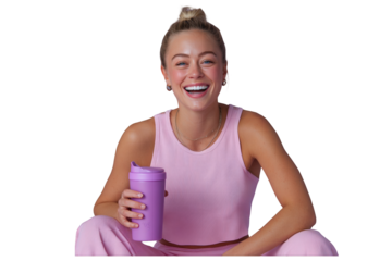 Joyful blonde woman with a top bun smiling brightly in a pink outfit holding a purple shaker.