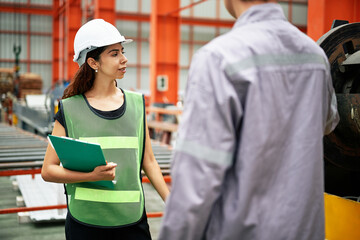 Engineer or technician training and teaching how to use machine control with coworker in factory