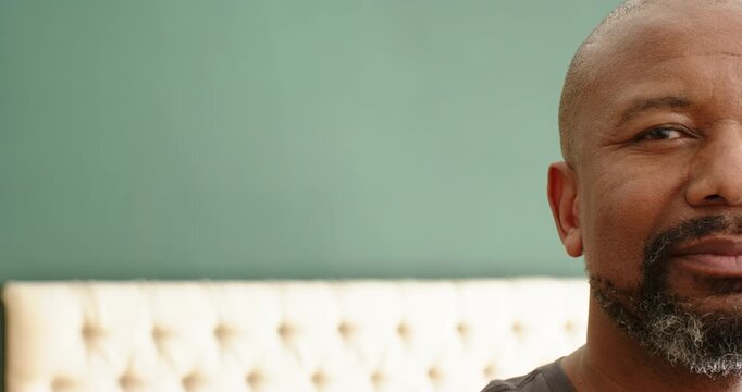 African American man shifting from neutral to smirk to laughter in bedroom by headboard, copy space