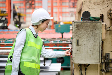 Engineer or worker working at machine control panel and push a button in the factory