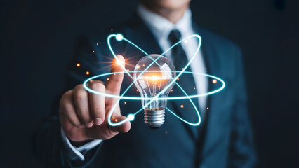 Businessman activating innovative idea with lightbulb and atom symbol