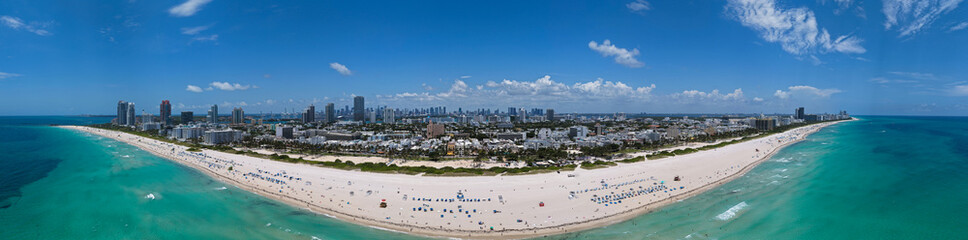 Obraz premium Aerial view of South Beach coastline. Miami skyline with tropical blue waters panorama. Panorama over the Miami skyscrapers. Miami, Florida waterfront cityscape. Iconic South Florida travel