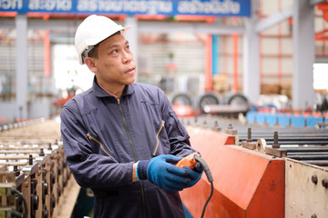 Engineer or worker operating remote switch to control machine in the factory