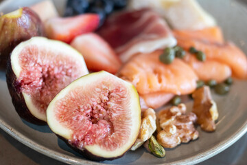 A vibrant plate featuring fresh figs, salmon, nuts, and various fruits, perfect for showcasing healthy eating and gourmet cuisine.
