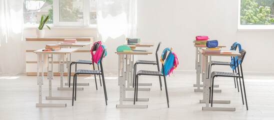 Interior of classroom with desks and backpacks