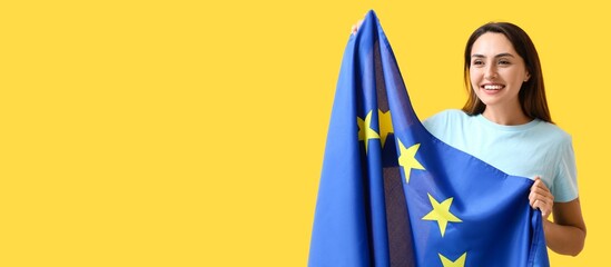 Young woman with flag of European Union on yellow background with space for text