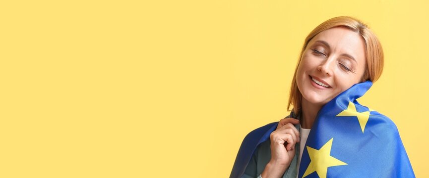 Mature woman with flag of European Union on yellow background with space for text