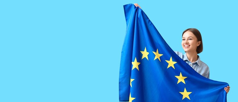 Young woman with flag of European Union on light blue background with space for text