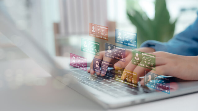 Hands typing on laptop with floating digital profile cards. Concept of online collaboration platform, remote team management, user data, virtual workspace, and professional networking tools.
