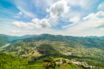 Obraz premium Charming Riverside Village Homes Nestled Among Enshi Mountains And Rivers