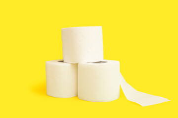 Rolls of toilet paper on yellow background