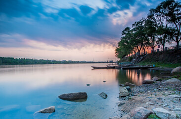 Atmospheric Blue Hue Sunset Over Scenic River Landscape Embraces Peaceful Evening Tranquility