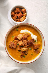 Bowl of tasty cream soup with croutons on white background