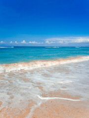 Vertical View Of Bali Beach With Blue Sky White Clouds And Rolling Waves