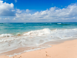 Bali Beach Scene With Blue Sky White Clouds And Gentle Ocean Waves