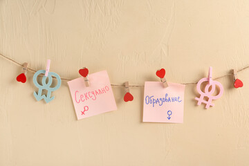 Rope and paper sheets with written text in Russian language on yellow background. Sexual education