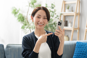 リビングでスマホを使う女性