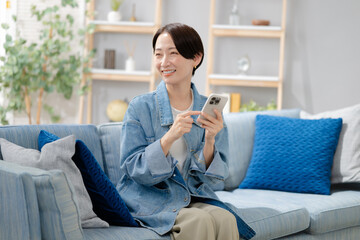 Obraz premium スマホを見るミドルの女性