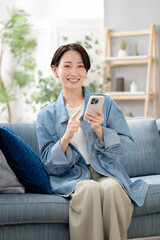 Obraz premium スマホを見るミドルの女性