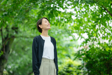 新緑の中に立つ女性