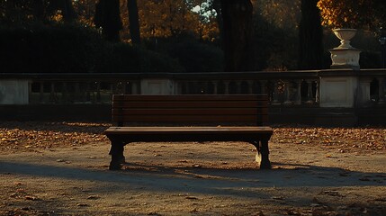 Empty wooden park bench on a ground covered with autumn leaves.