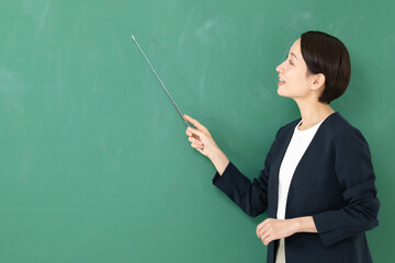 黒板の前に立つ女性